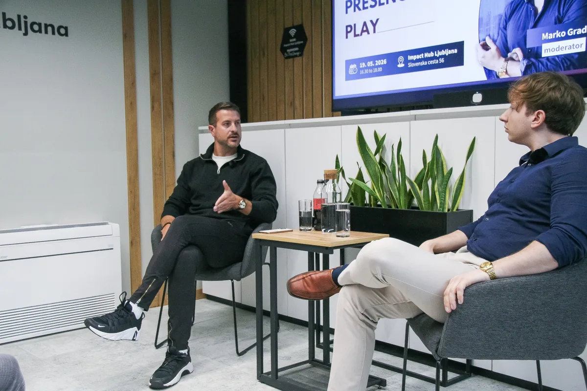 Guest Klemen Selakovič in conversation with moderator Marko Grad, the two seated either side of a small table on the Impact Hub Ljubljana stage.
