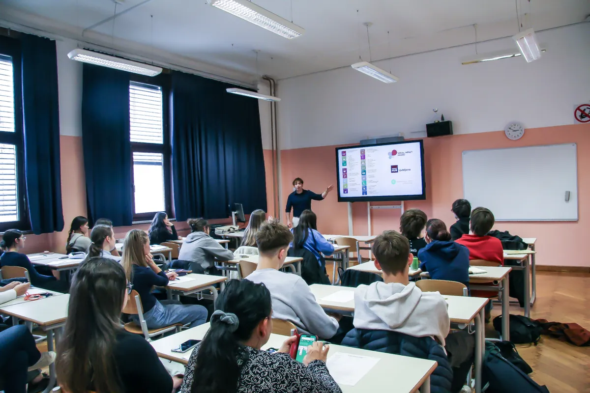 A Shaper presenting at the front of the classroom at Gimnazija Bežigrad, the students following from their desks.