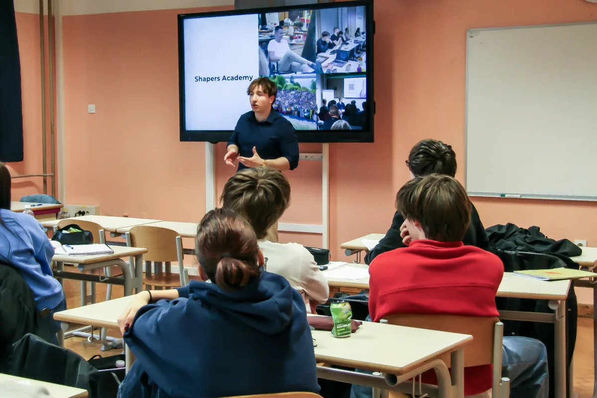 The Shapers Academy presentation seen from the back of the class, the students at their desks facing the screen.
