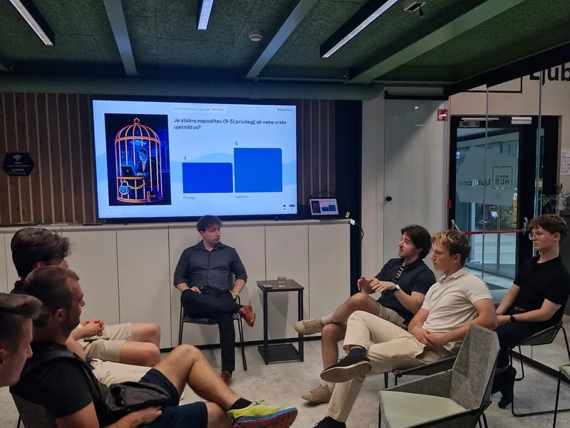 A Shape Talks debate at Impact Hub Ljubljana, the audience seated in a circle facing a screen with a live poll